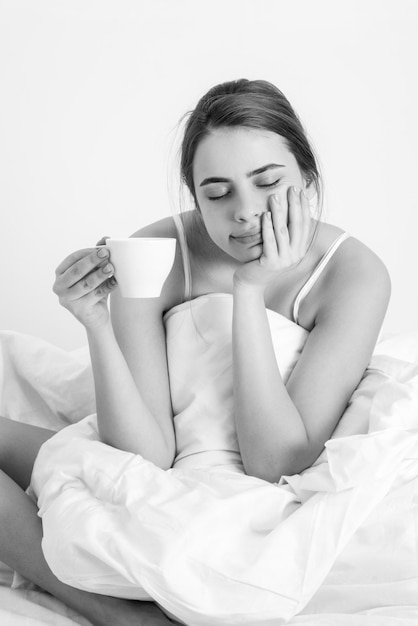 Frau mit Morgenkaffee auf dem Bett