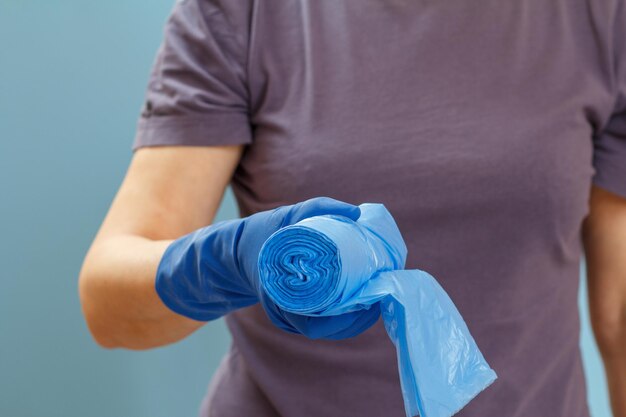 Frau mit Müllsäcken auf blauem Hintergrund