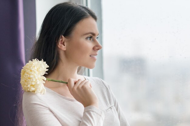 Frau mit natürlichem Make-up, mit großer hellgelber Blume