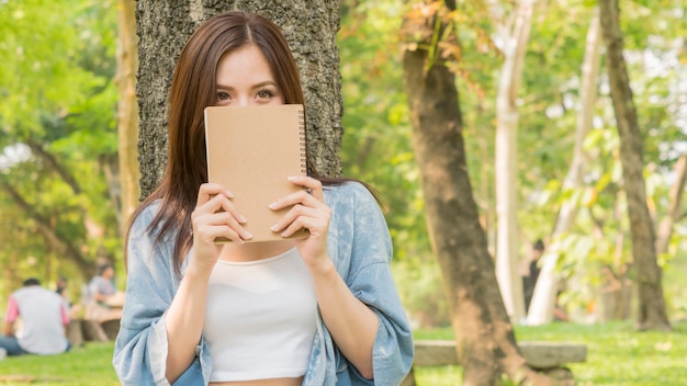 Frau mit Notizbuch im Park