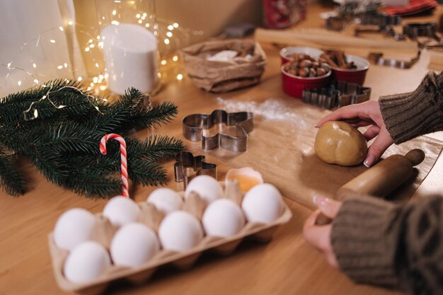 Frau mit nudelholz für die herstellung von lebkuchen nahaufnahme des rollens von rohem teig für lebkuchen