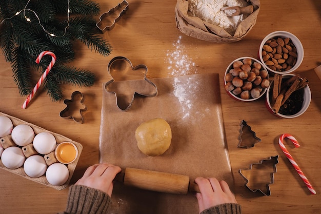 Frau mit Nudelholz für die Herstellung von Lebkuchen Nahaufnahme des Rollens von rohem Teig für Lebkuchen