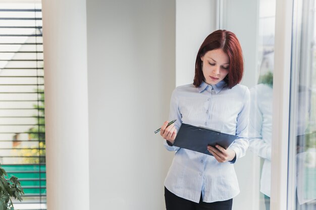 Foto frau mit ordner im büro