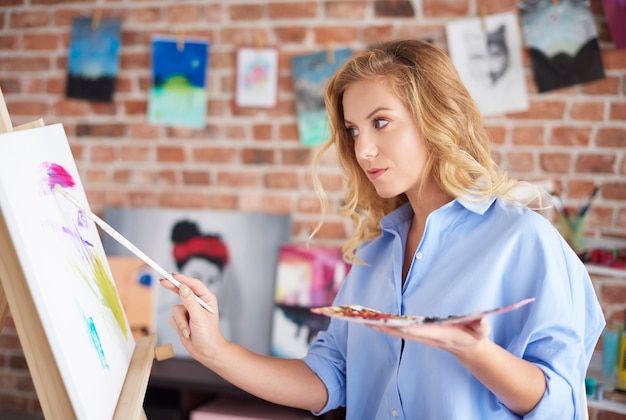 Frau mit Palette neben Staffelei