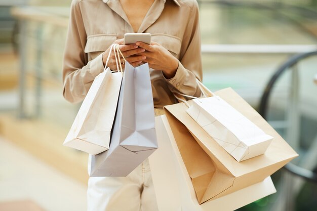 Frau mit Papiertüten und Telefon