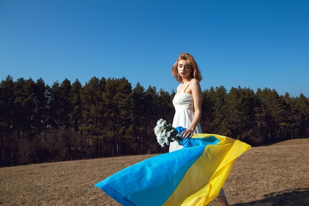 Frau mit patriotischem Make-up in ukrainische Flagge gehüllt Stand mit Ukraine-Konzept