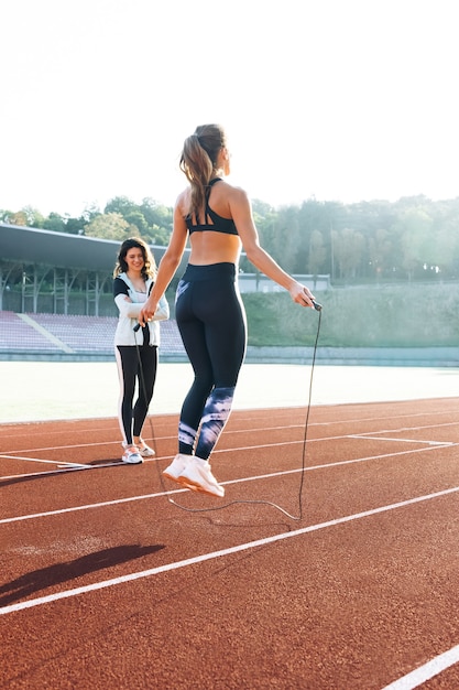 Frau mit Personal Trainer Seilspringen als Teil ihres Fitnesstrainings sportliche Frau