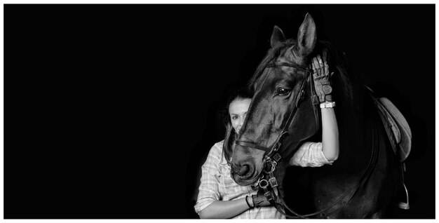 Foto frau mit pferd auf schwarzem hintergrund