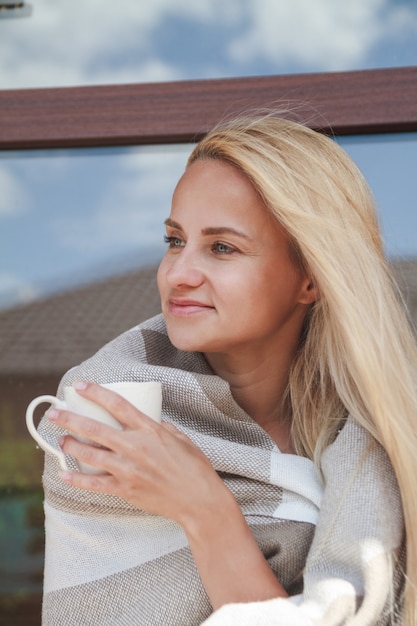 Frau mit Plaid und Kaffeetasse