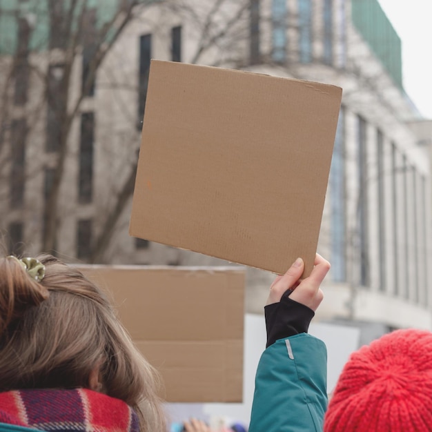 Frau mit Plakat in der Hand vor dem Hintergrund des feministischen Protestkopierraums