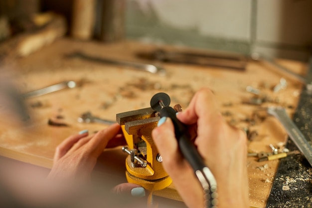 Frau mit Power Working Grinder Machine weibliche Hand schleift Metallnüsse