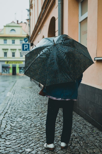 Frau mit Regenschirm an einem regnerischen Tag in der Stadt