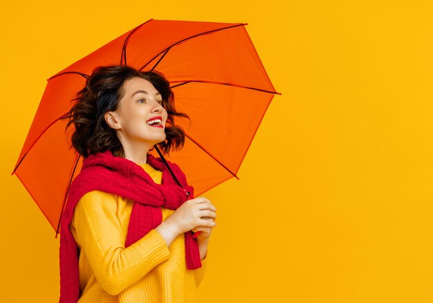 Frau mit Regenschirm auf farbigem Hintergrund