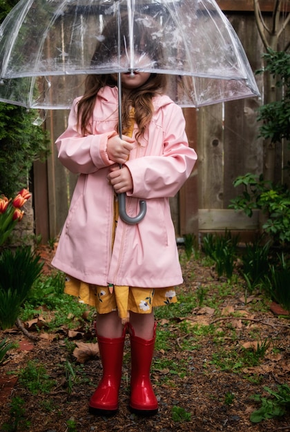 Frau mit Regenschirm, die während der Regenzeit im Regen steht