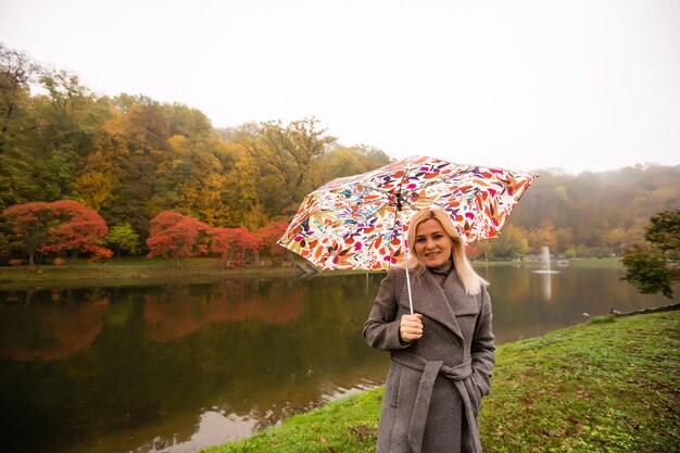 Frau mit Regenschirm im Herbstpark