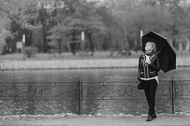 Frau mit Regenschirm im Herbstpark