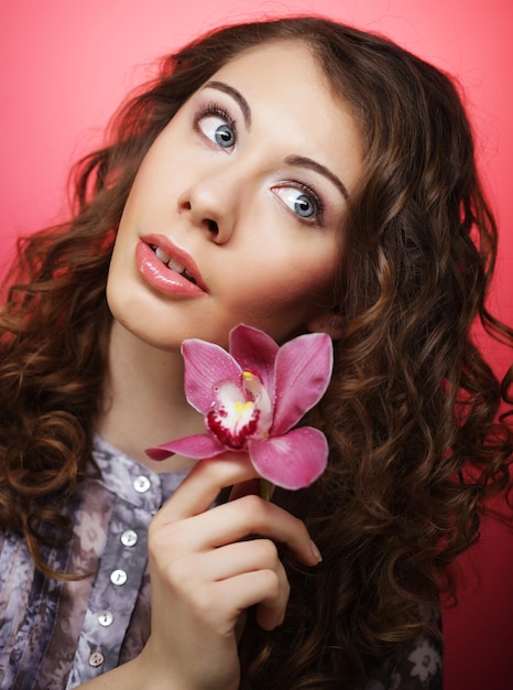 Frau mit rosa Blume über rosa Hintergrund