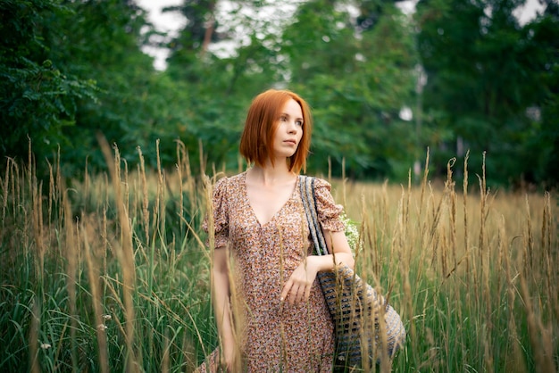 Frau mit roten Haaren 40 Jahre alt auf einem Feld im Sommer