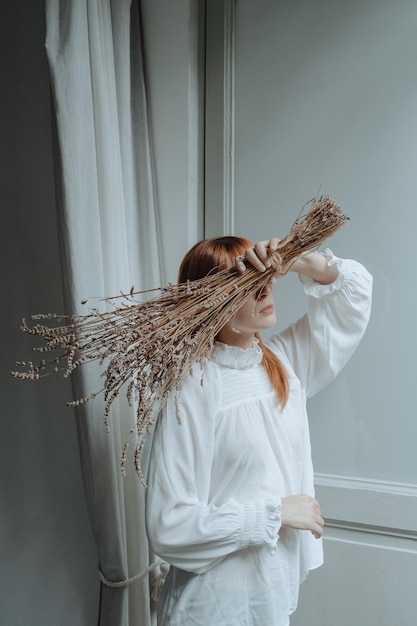 Frau mit roten Haaren und mit einem von Blumen bedeckten Gesicht