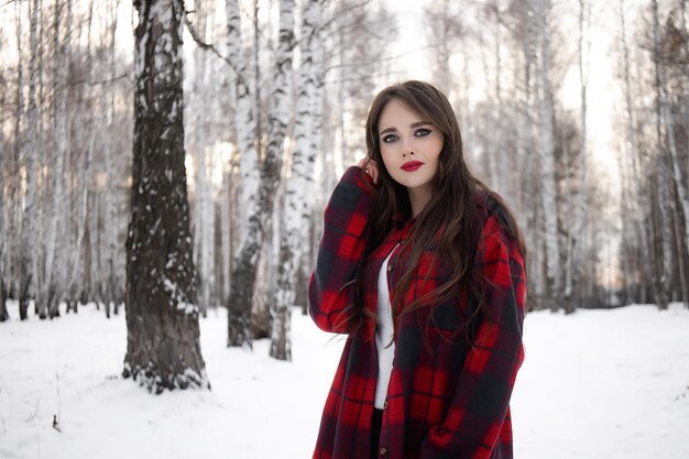 Frau mit roten Lippen im Winterwald