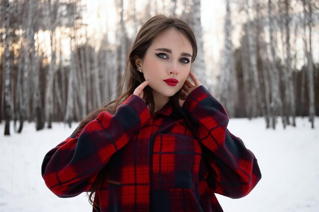 Frau mit roten Lippen im Winterwald