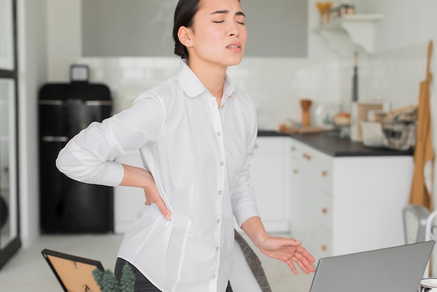 Foto frau mit rückenschmerzen von der arbeit