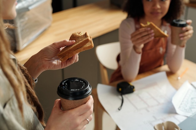 Frau mit Sandwich und einer Tasse Kaffee