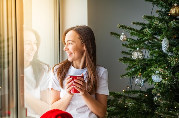 Frau mit Schale nahe Weihnachtsbaum