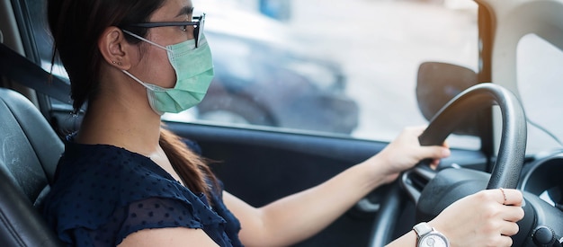 Frau mit schützendem Gesichtsmaskenauto gegen Coronavirus