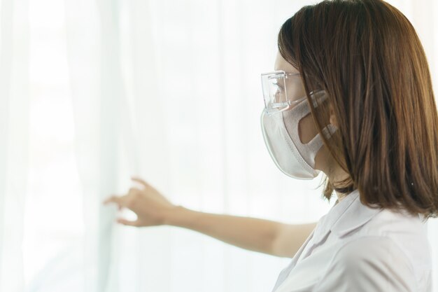 Frau mit Schutzbrille und Maske, um die Ausbreitung des Coronavirus zu vermeiden.