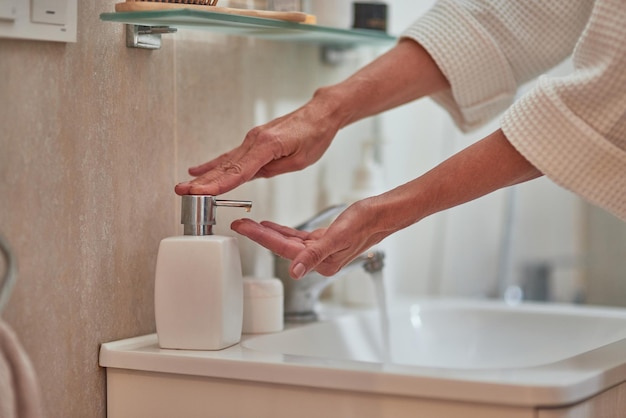 Frau mit Seifenspender im Badezimmer