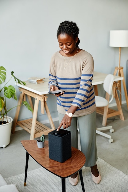 Frau mit Smart Speaker zu Hause