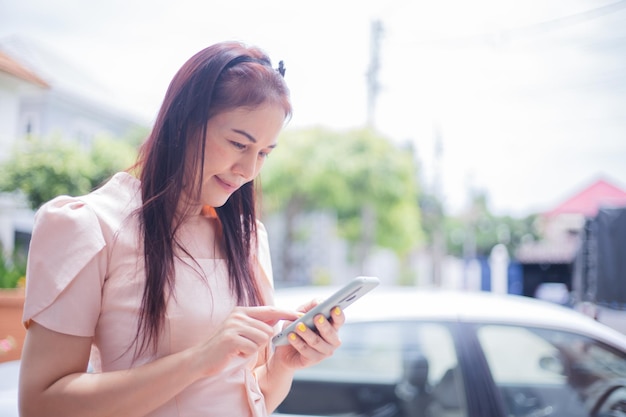 Frau mit Smartphone am Straßenrand nach VerkehrsunfallVerkehrssicherheit und Versicherungskonzept