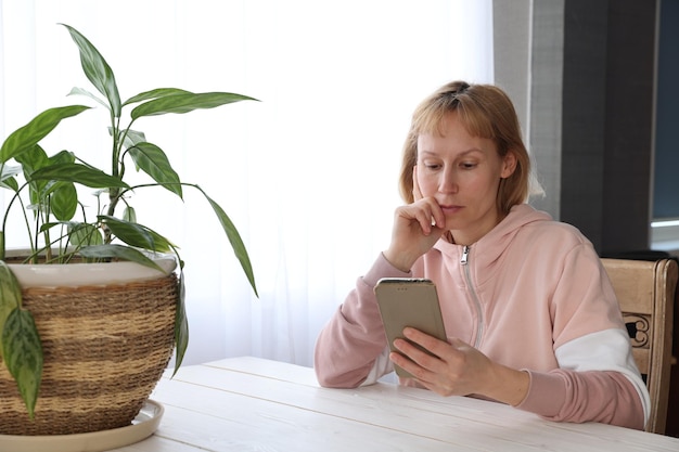 Frau mit Smartphone am Tisch