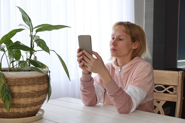 Frau mit Smartphone am Tisch