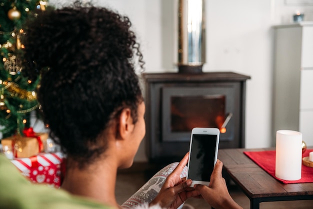 Frau mit Smartphone an Weihnachten