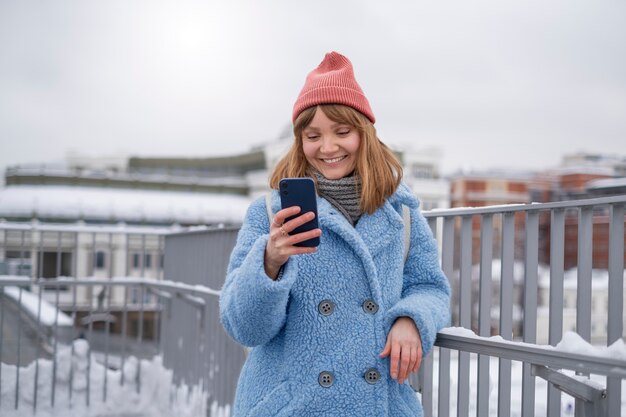 Foto frau mit smartphone auf der straße