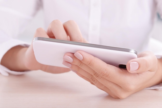 Frau mit Smartphone auf hellem Hintergrund