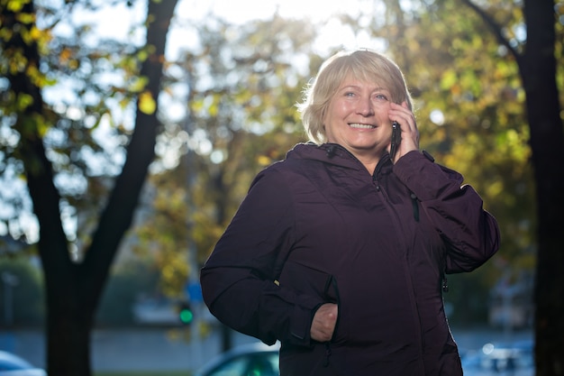 Frau mit Smartphone im Freien im Herbst