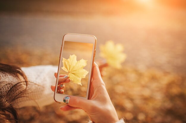 Frau mit Smartphone im Herbst