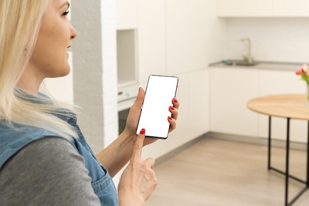 Frau mit Smartphone im Smart House, leerer Bildschirm.