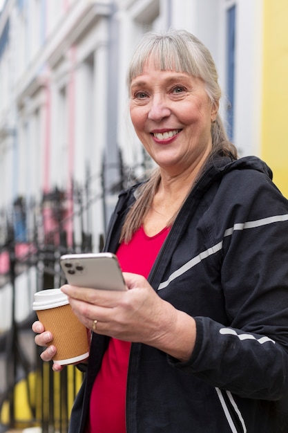 Foto frau mit smartphone mittlerer aufnahme