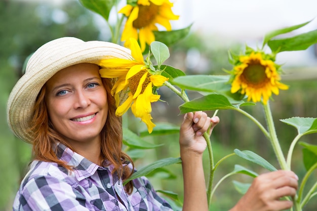 Frau mit Sonnenblumen im Garten