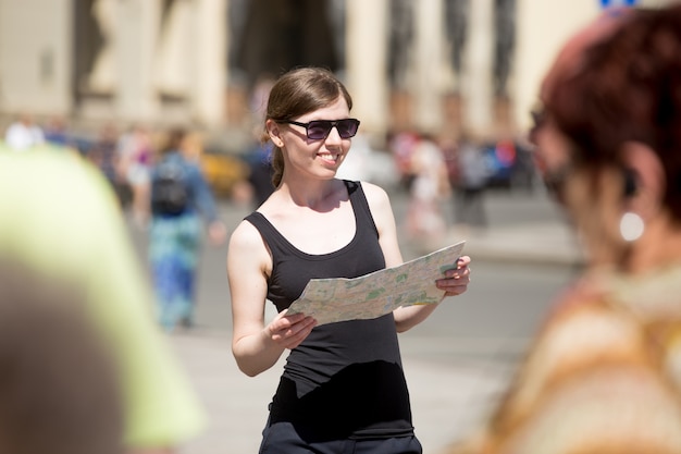 Frau mit Sonnenbrille auf einer Karte suchen