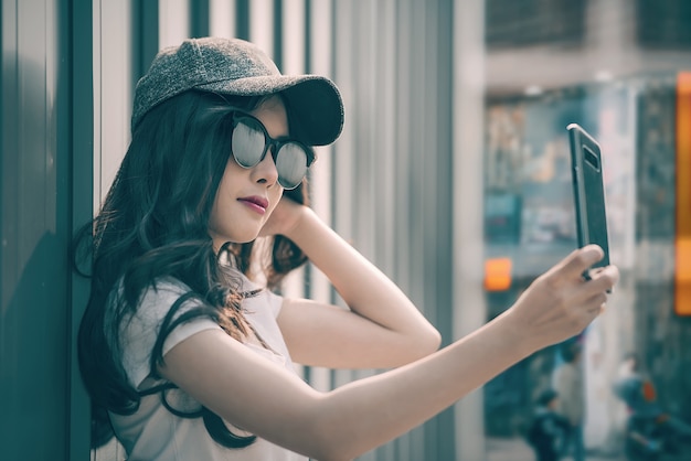 Frau mit Sonnenbrille nehmen Selfie mit Smartphone