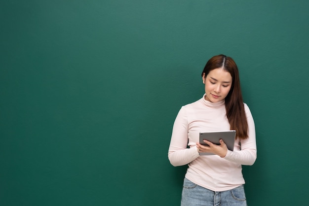 Frau mit Tablette auf grüner Wand