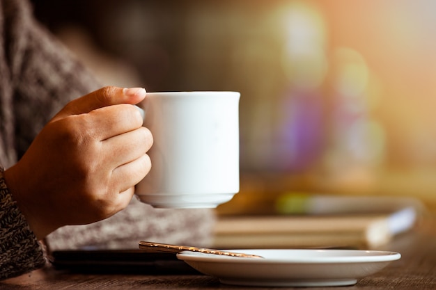 Frau mit Tablette in einem Café am regnerischen Tag Weinlesefarbton