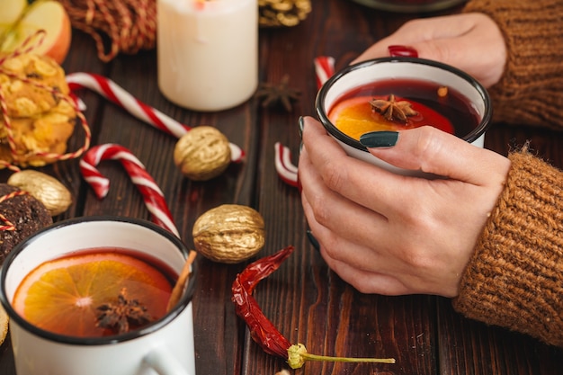 Frau mit Tasse mit Glühwein in den Händen