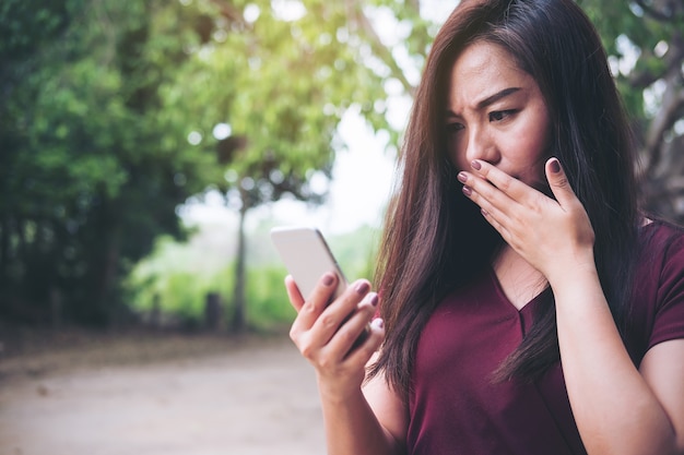 Frau mit Telefon mit Gefühl erschrocken