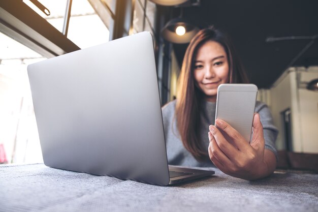 Frau mit Telefon und Computer Laptop